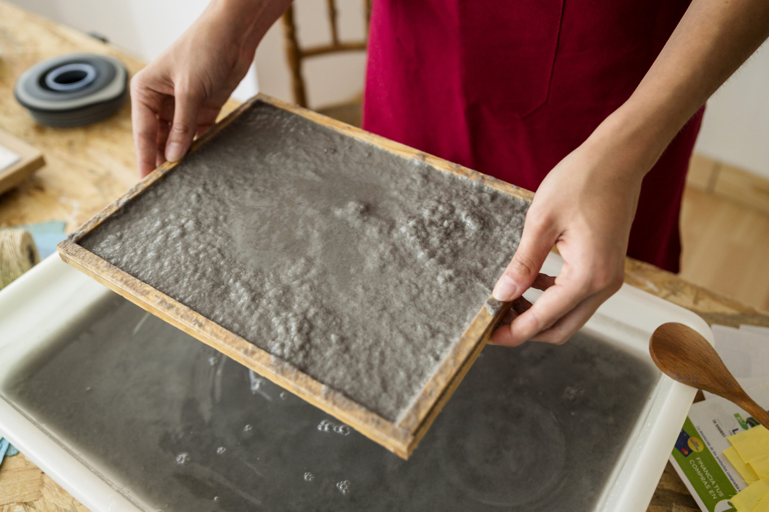 female-s-hand-holding-mold-with-paper-pulp